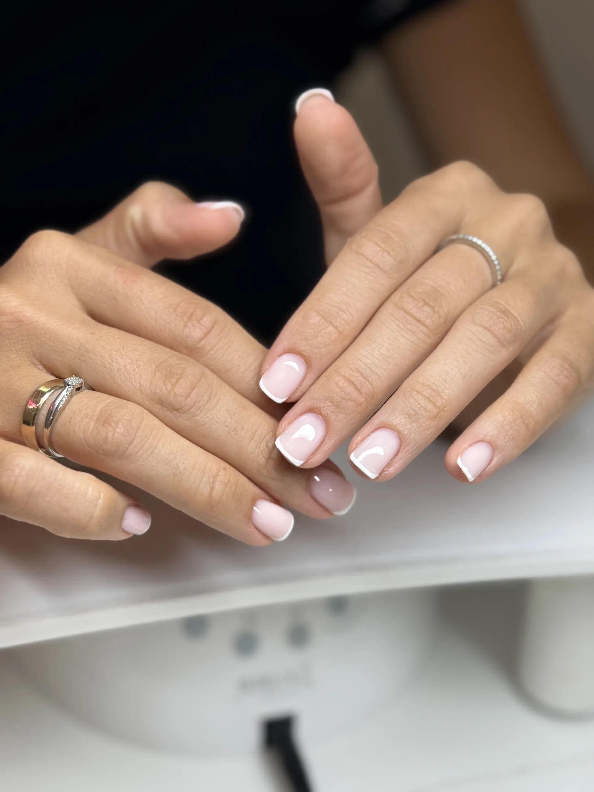 Soft pink French manicure with fine white tips on natural-looking nails