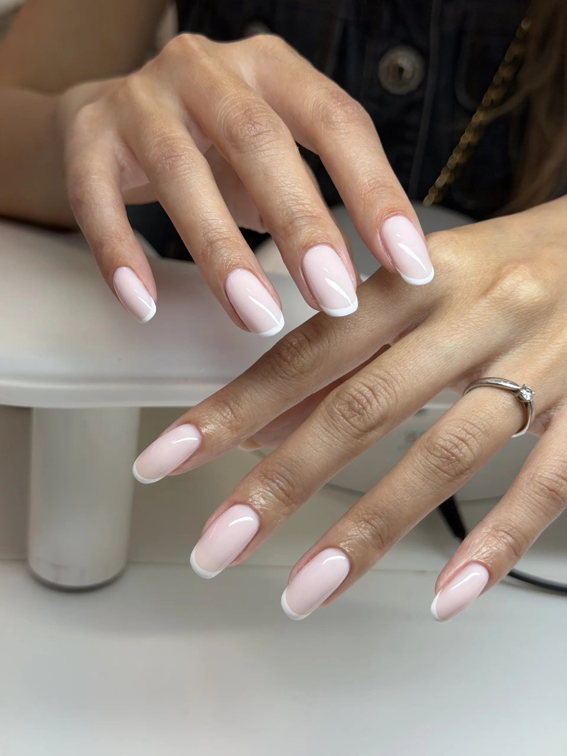 Elegant white French tips on soft pink almond shaped nails