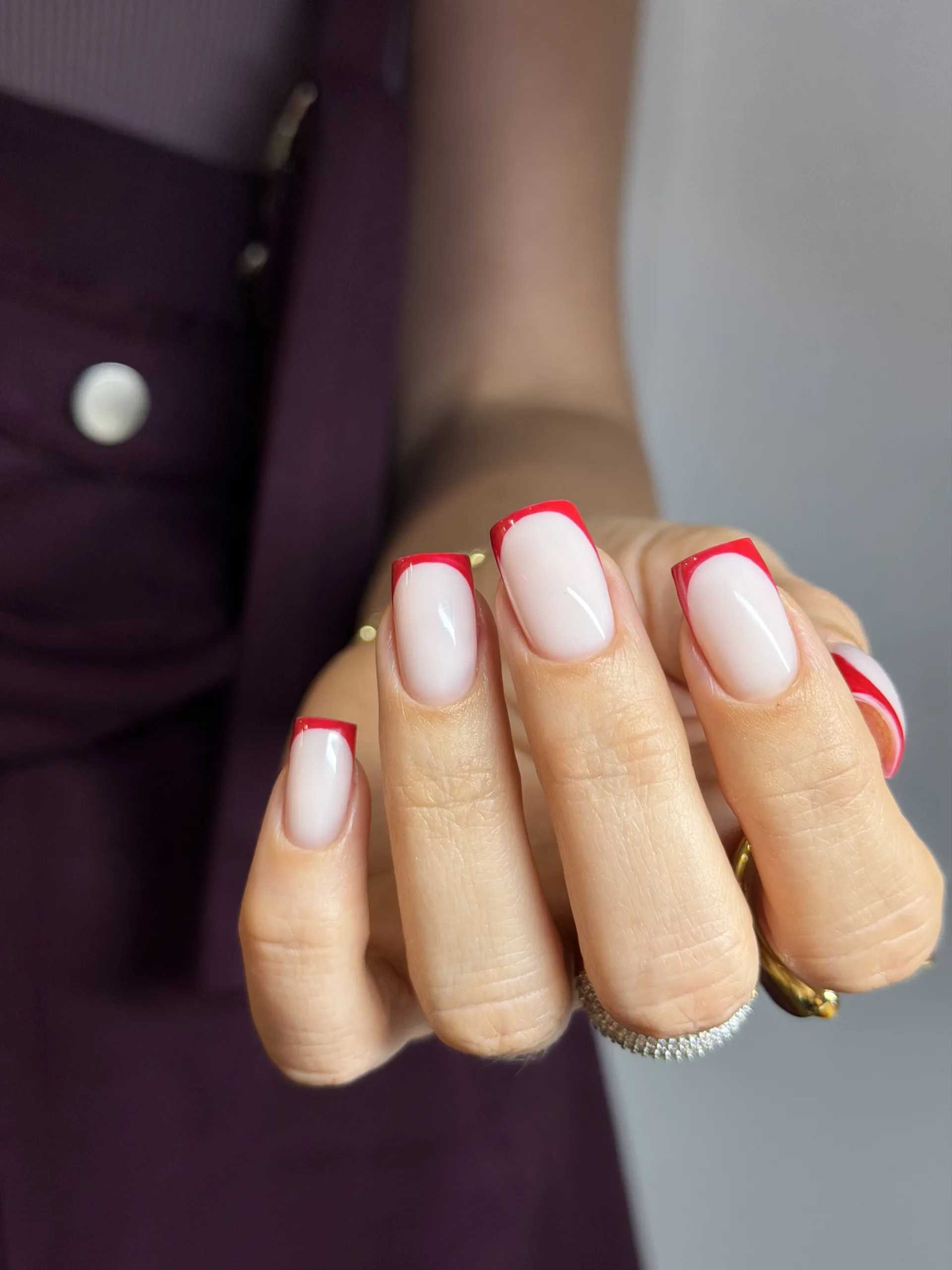 Bright red French tips on glossy nude square nails